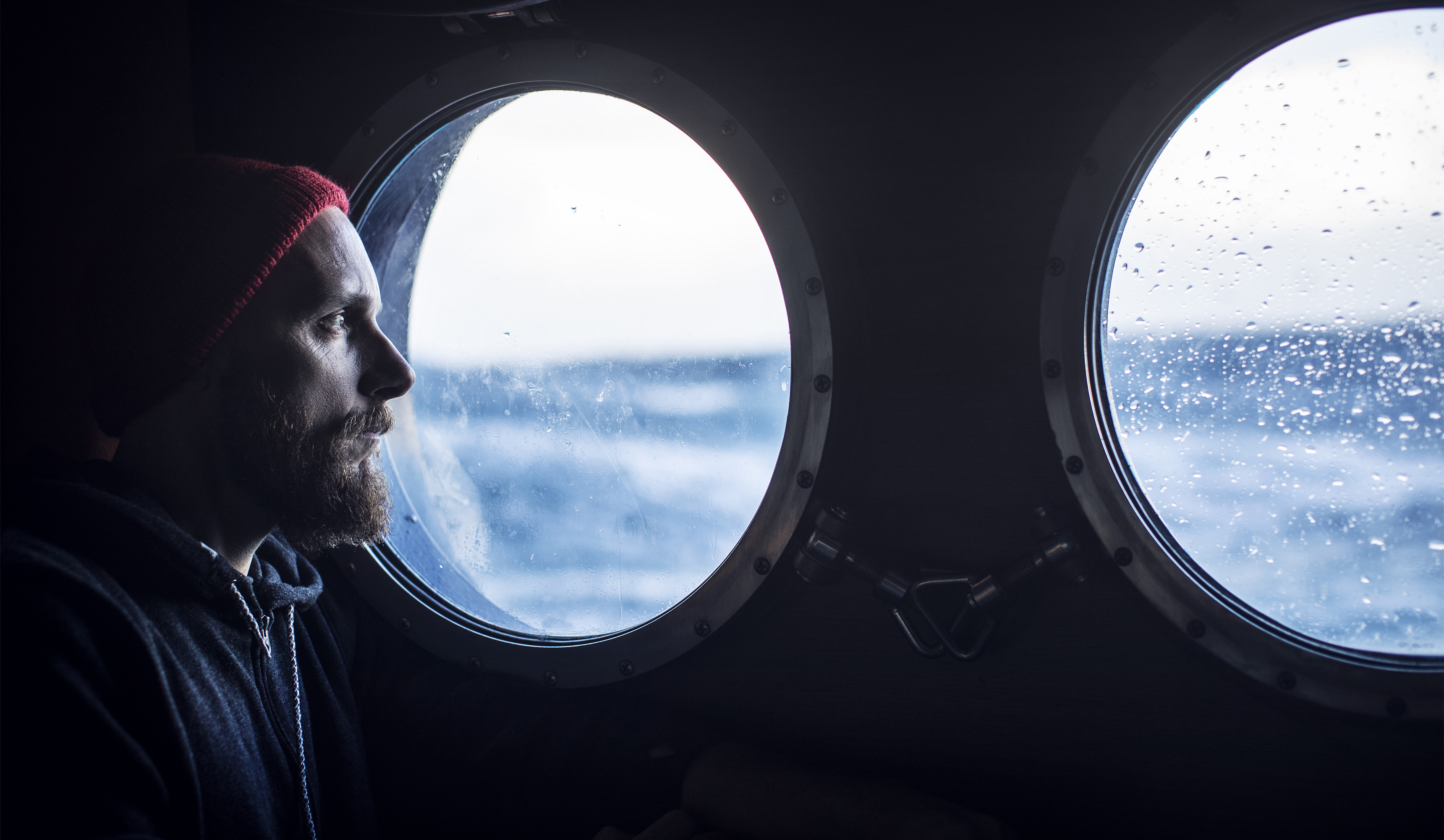 A seafarer looking out of a ship's porthole